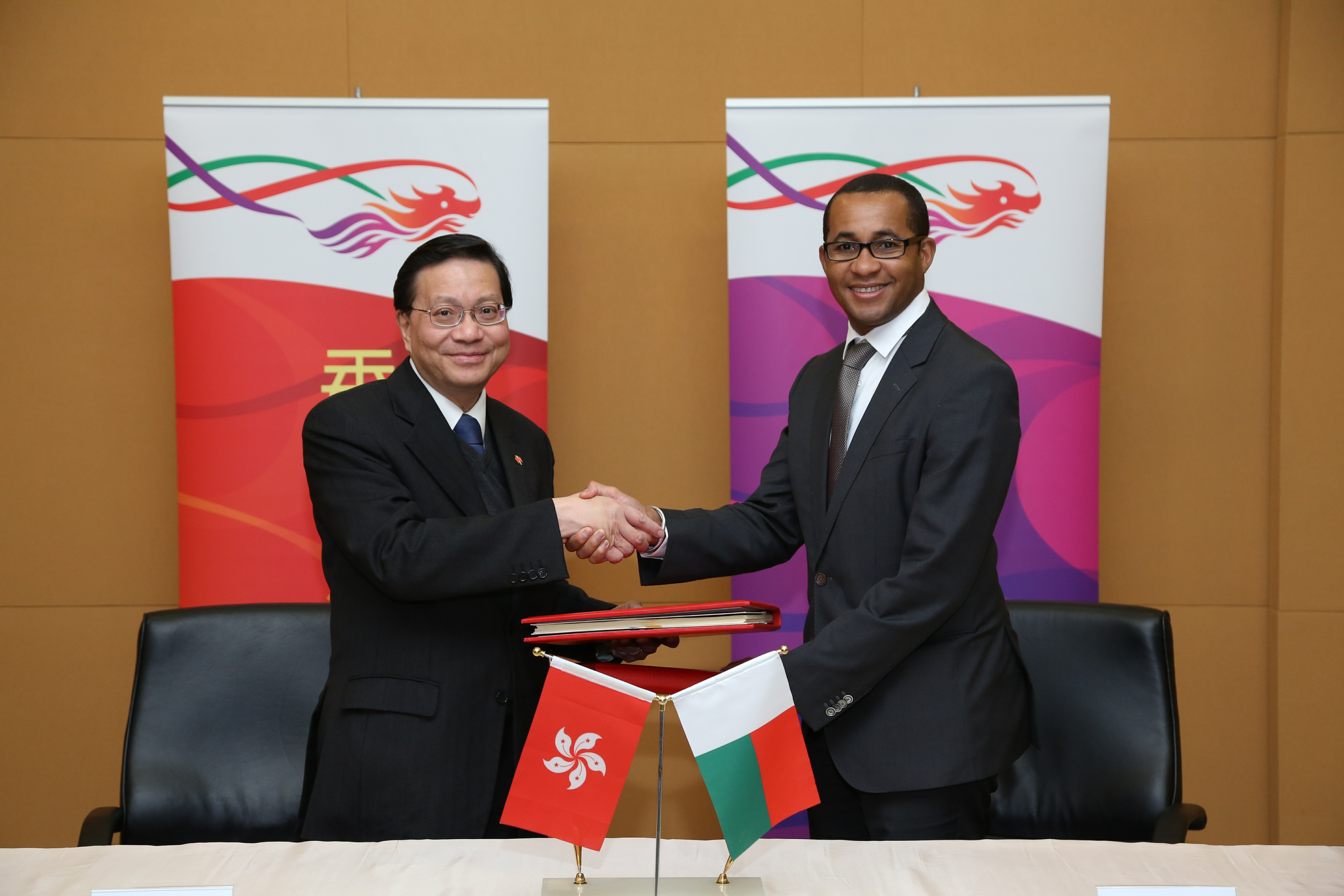 张炳良教授（左）与Ulrich Adriantiana签署香港与马达加斯加之间的民用航空运输协定后交换文件。 