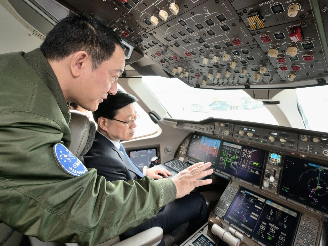 行政長官李家超出席C919及ARJ21飛機歡迎儀式後，聽取中國商用飛機有限責任公司飛行工程總師佟宇（左）介紹C919駕駛艙。