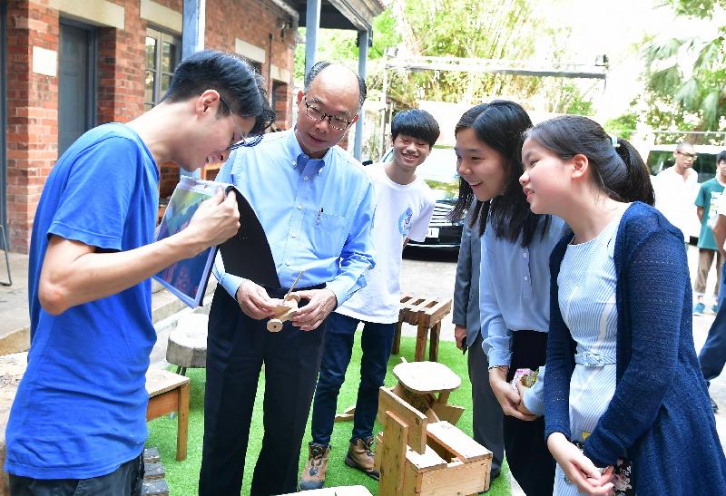 運輸及房屋局局長陳帆（左二）今日（七月二十五日）到訪位於南區的蒲窩青少年中心，兩名參加「與司局長同行」計劃的中學生亦有同行。木工導師向他們介紹中心學員的作品。