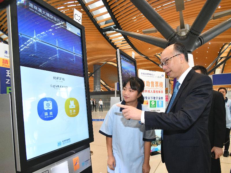 運輸及房屋局局長陳帆今日（十月二十四日）上午到港珠澳大橋香港口岸，視察大橋開通的準備工作。圖示陳帆（右）在旅檢大樓出境大堂了解穿梭巴士自助售票機的運作情況。